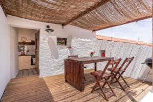 阿尔热祖尔Casa Alfambras - Holiday Cottage in Aljezur的一间带木桌和椅子的用餐室