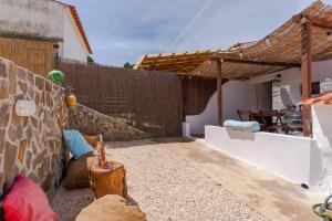 阿尔热祖尔Casa Alfambras - Holiday Cottage in Aljezur的后院设有木栅栏和桌子