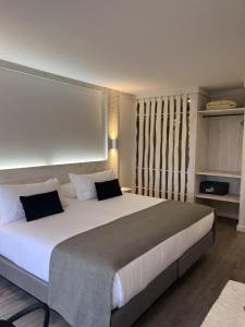 纳塔列斯港Hotel Costanera的一间卧室配有一张带白色床单的大床