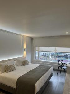纳塔列斯港Hotel Costanera的一间卧室设有一张大床和大窗户