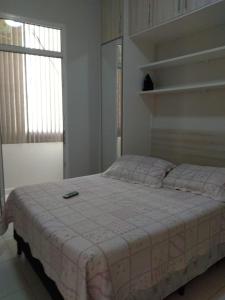 里约热内卢Quarto e Sala completo的一间卧室配有一张床,上面有手机