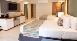 圣斐利-银港Emotions by Hodelpa Puerto Plata的酒店客房设有两张床和电视。