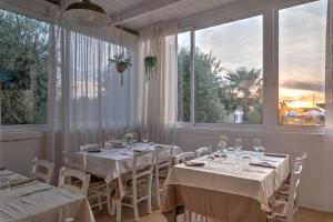托雷桑塔萨宾娜瑞福斯酒店的用餐室设有白色桌子和大窗户