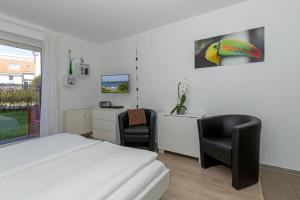 奥斯赛拜-屈隆斯博恩Yachthafenresidenz-Wohnung-8105-9733的一间卧室配有一张床、一张桌子和两把椅子