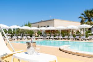托雷桑塔萨宾娜瑞福斯酒店的游泳池旁的桌子和玻璃杯