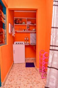 埃尔多雷特CasaAloha Homes- Cozy 1Bdr - Along Eldoret-Kisumu Highway - Near the Edge Bar and Restaurant的厨房设有橙色墙壁和炉灶。