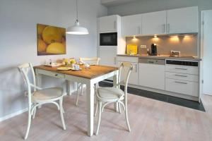 奥斯赛拜-屈隆斯博恩Residenz-Ostseewind-Wohnung-15-9732的一间厨房,里面配有桌椅