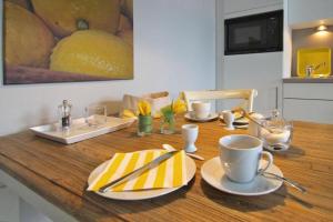 奥斯赛拜-屈隆斯博恩Residenz-Ostseewind-Wohnung-15-9732的一张木桌,上面有盘子和杯子