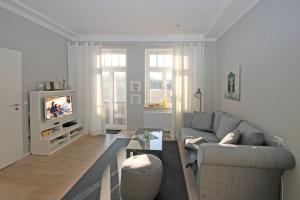 奥斯赛拜-屈隆斯博恩Residenz-Ostseewind-Wohnung-15-9732的带沙发和电视的客厅