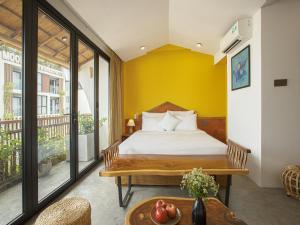岘港TA Danang Boutique Hotel的一间卧室配有一张黄色墙壁的床