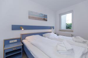 奥斯赛拜-屈隆斯博恩Yachthafenresidenz-Wohnung-5103-807的一间卧室配有一张带白色床单的床和一扇窗户。