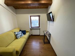 洛雷托Appartamento incantevole sull'antica via Lauretana的客厅配有黄色沙发和电视