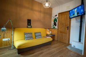 潘通Fogar do Pumar的客厅设有一张黄色沙发,配有电视