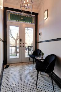 蒙特利尔Villa Dante By Denstays的一间设有两把椅子和一张桌子的房间,以及一扇门