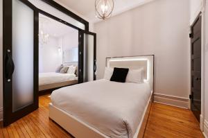 蒙特利尔Villa Dante By Denstays的卧室配有一张白色大床和镜子