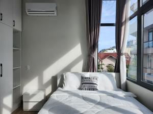 头顿An Home - Phòng đơn ngay bãi sau Vũng Tàu的一间卧室设有一张床和一个大窗户