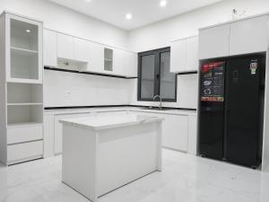 头顿An Home - Phòng đơn ngay bãi sau Vũng Tàu的厨房配有白色橱柜和黑色冰箱。
