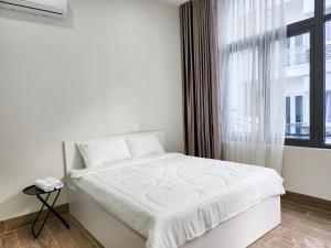 头顿An Home - Phòng đơn ngay bãi sau Vũng Tàu的窗户客房内的一张白色床