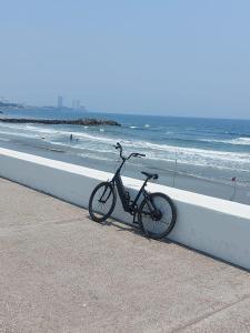 博卡德尔里奥HOTEL INTI的停在海滩上墙上的自行车