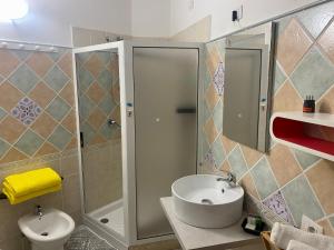 奇亚L'Oasi di Chia的带淋浴、盥洗盆和卫生间的浴室