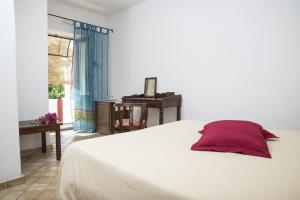 马尔法Il格尔索假期酒店的卧室配有白色的床和红色枕头