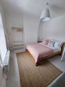 利物浦Cosy modern house的一间卧室配有一张带地毯和灯的床
