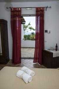 马尔法Il格尔索假期酒店的卧室配有带2条毛巾的窗户,位于床上