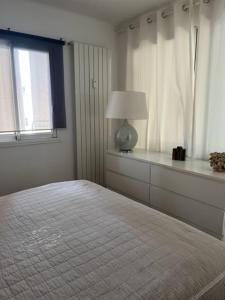 锡富尔勒普拉日Le murât的白色的卧室设有床和窗户