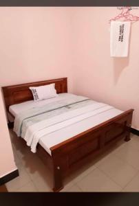 MUSITA GUEST WING MOTEL的卧室内的一张床铺,配有木制床架