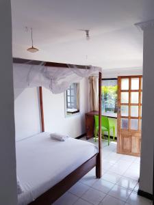 LimbeChinyonga Guesthouse的一间卧室配有一张床和一把绿色椅子