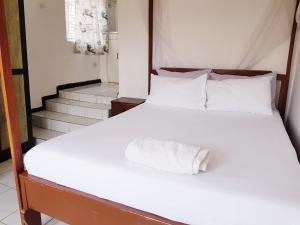 LimbeChinyonga Guesthouse的一张白色的床,上面有一条毛巾
