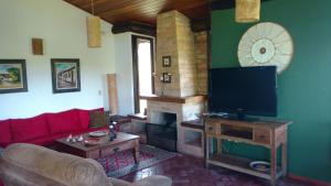 陶巴特chale da montanha的一间带电视和壁炉的客厅