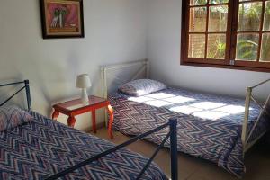 佩洛塔斯Casa ampla no Laranjal的配有桌子和窗户的客房内的两张床