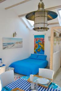 帕里斯特Apartment Mediterraneo Blue Sky的客厅配有蓝色的床和一张桌子