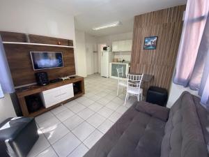 坎皮纳斯Apart 2 suítes Prox Cambuí Wi-Fi Gar Var Note Pet ap21的带沙发和电视的客厅以及厨房。