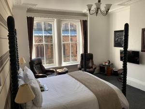 惠特比米德尔赫姆酒店的一间卧室配有一张床、两把椅子和一个窗户
