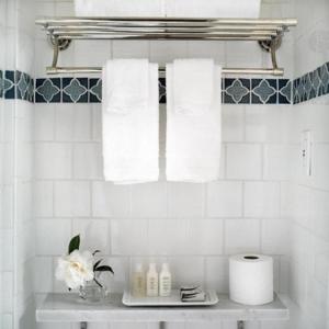 洛杉矶布伦特伍德酒店 的浴室提供白色毛巾和带毛巾的架子。