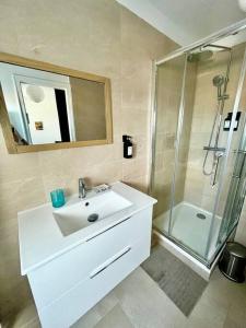 多维尔Un été sans fin à Deauville的白色的浴室设有水槽和淋浴。