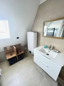 多维尔Un été sans fin à Deauville的浴室设有白色水槽和镜子