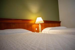 阿瓜斯迪林多亚Hotel Monte Real的酒店客房,设有两张床和一盏灯