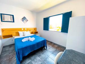 阿拉卡茹Pousada Villa Grécia的一间卧室设有蓝色的床和窗户。
