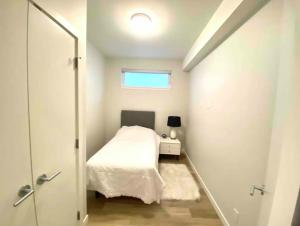 悉尼Brand New 3-Bedroom Condo in the Heart of Sidney的一间小卧室,配有床和窗户