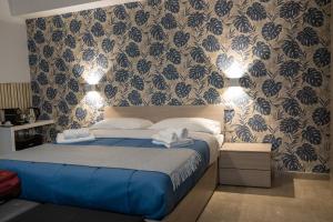 墨西拿Dolce Vita的一间卧室配有一张带蓝色床单和壁纸的床。