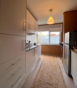 阿马马尔Douro Valley Terrace Apartments的一间厨房,配有白色的橱柜和大窗户
