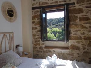 Cortes de ArenosoLa Esencia Casa Rural的卧室设有石墙窗户