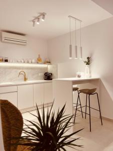 赫瓦尔Oleander Apartment & Room Centar的厨房配有白色橱柜和桌椅