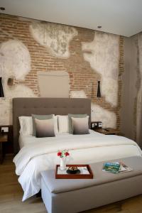 普埃布拉Cartesiano Boutique & Wellness Hotel的一间卧室设有一张大床和砖墙
