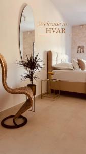 赫瓦尔Oleander Apartment & Room Centar的一间卧室配有一张床、镜子和椅子