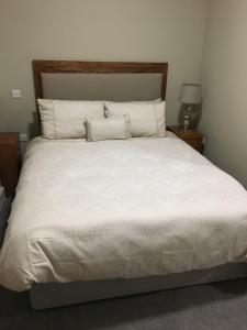 Teach MunnaCuckoos Corner的卧室配有一张带白色床单和枕头的大床。