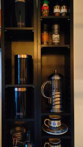 阿克雷里Studio White Bears的黑色橱柜,配有茶壶和盘子